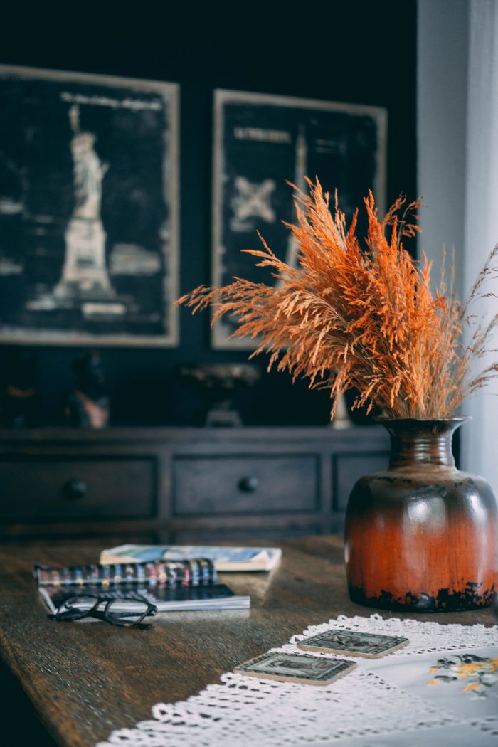 product-04 Warm and inviting autumn setting with a rustic vase filled with wheat, cozy decorations, and books.